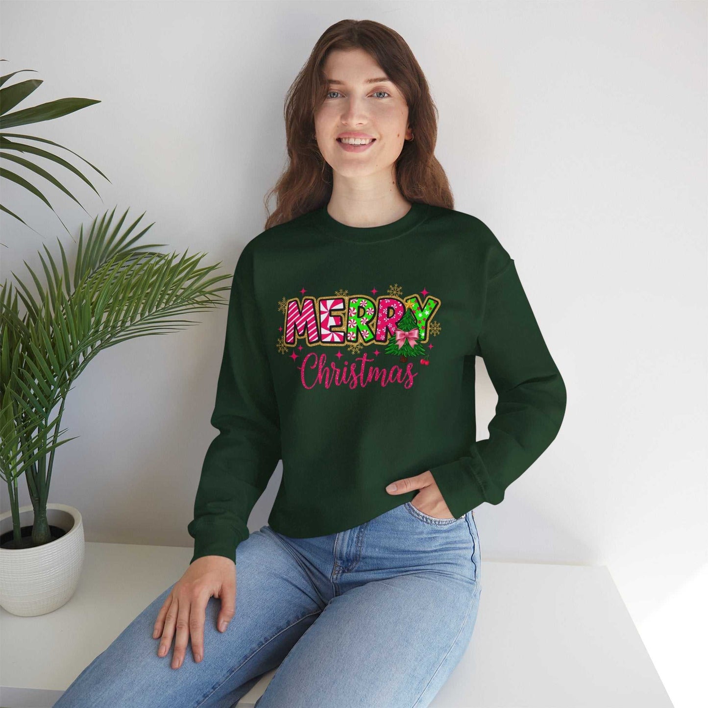 Woman wearing green Merry Christmas Candy Cane typography sweatshirt sitting indoors