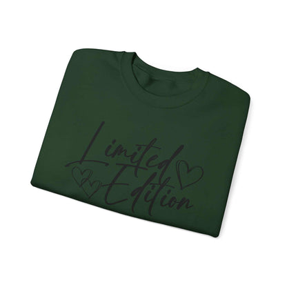 Folded green crewneck sweatshirt with black "Limited Edition" script and heart designs on the chest