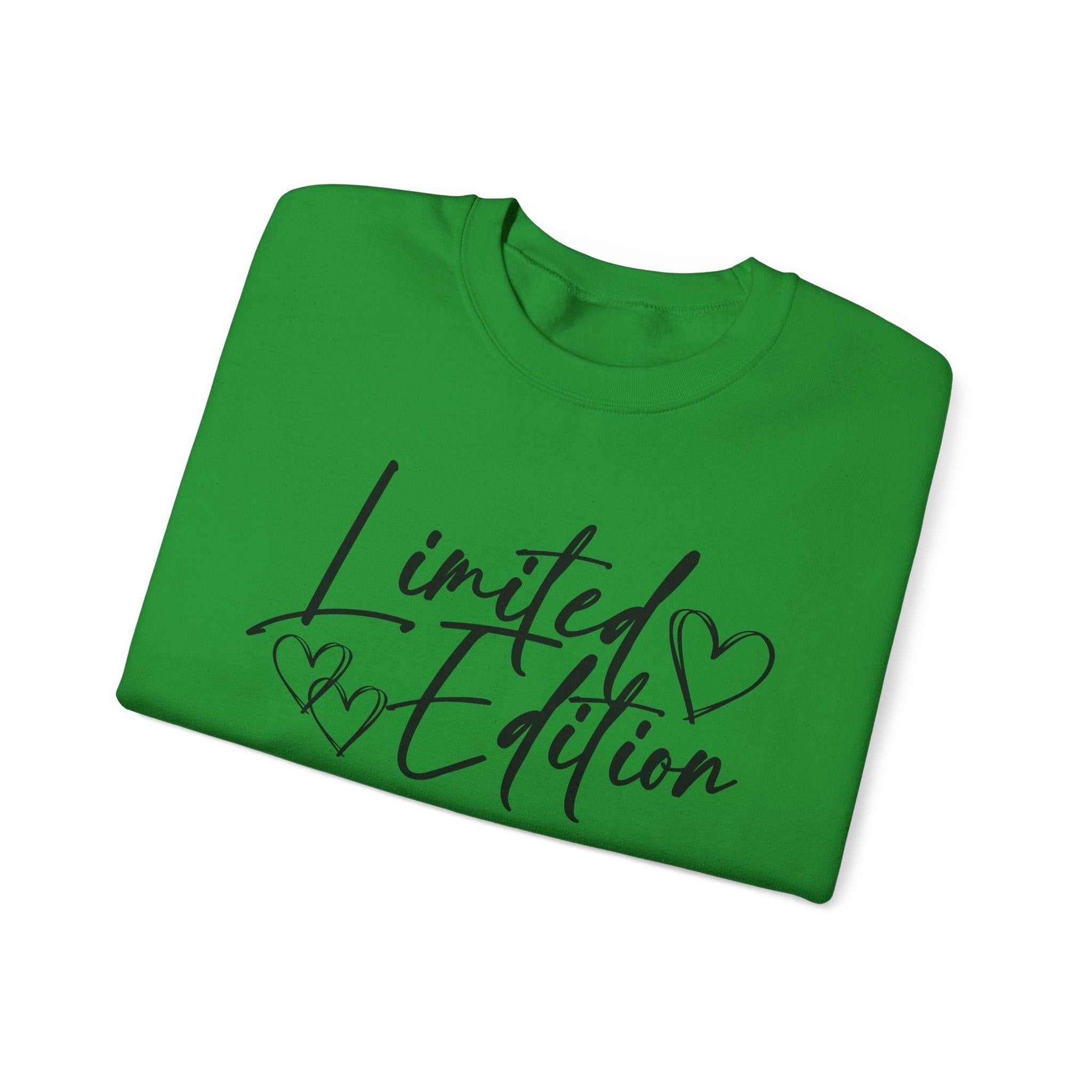 Folded green sweatshirt with black script "Limited Edition" and heart designs on the chest, crewneck style.