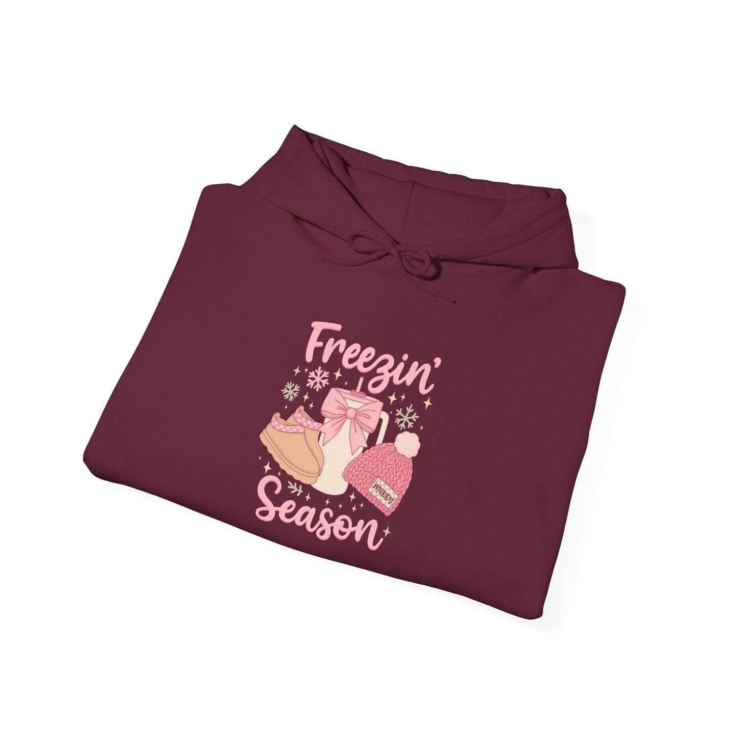 Folded maroon hoodie with winter boots, hat, mittens graphic and "Freezin' Season" text design