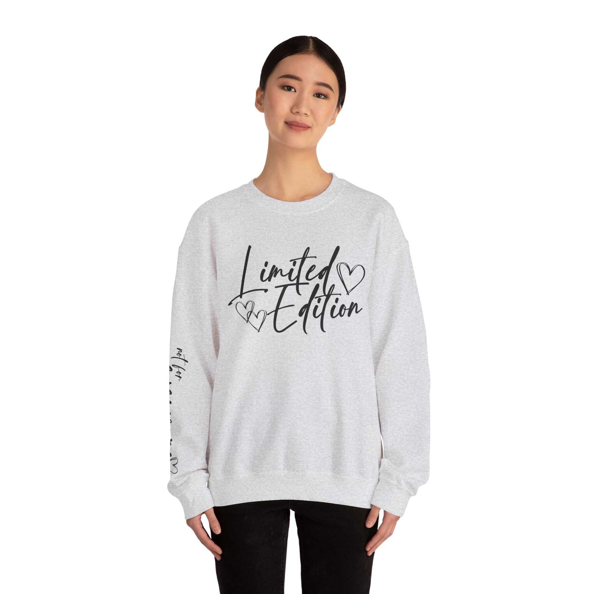 woman wearing white crewneck sweatshirt with black "Limited Edition" script and heart designs on chest and sleeve