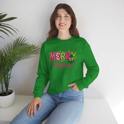Woman wearing green Merry Christmas Candy Cane typography sweatshirt sitting by plant