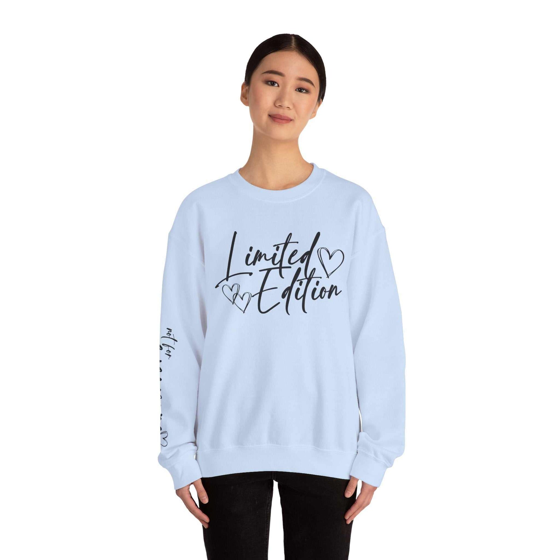 woman wearing white crewneck sweatshirt with black script limited edition and hearts design on chest and sleeve
