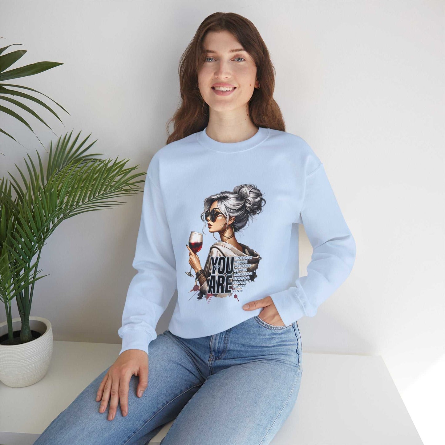 Chic woman with silver hair wearing light blue sweatshirt holding wine glass You Are Loved graphic design