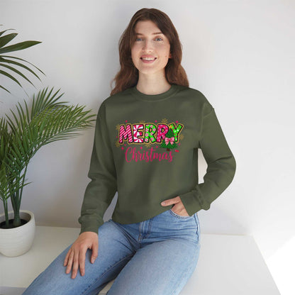 Woman wearing green Merry Christmas Candy Cane typography sweatshirt sitting by white table with plant