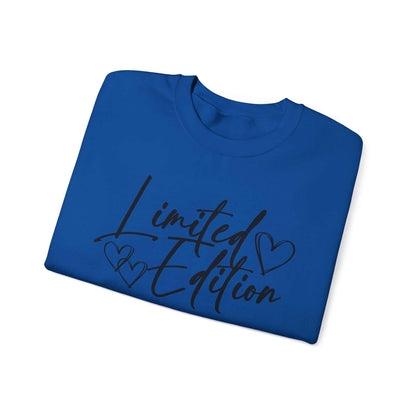 Folded blue crewneck sweatshirt with black limited edition script and heart designs on front