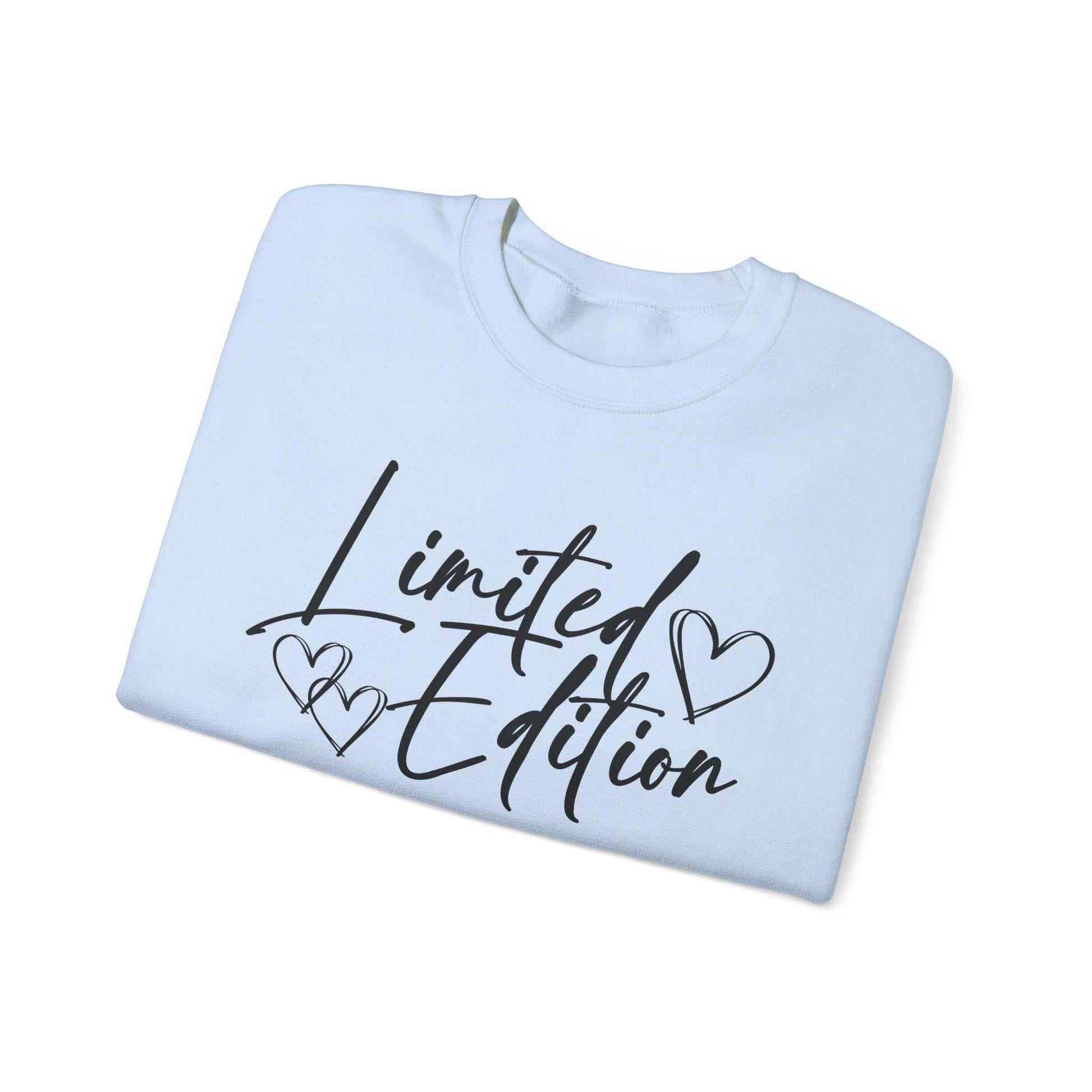 Folded white crewneck sweatshirt with "Limited Edition" script and hand-drawn hearts on chest and sleeve detail