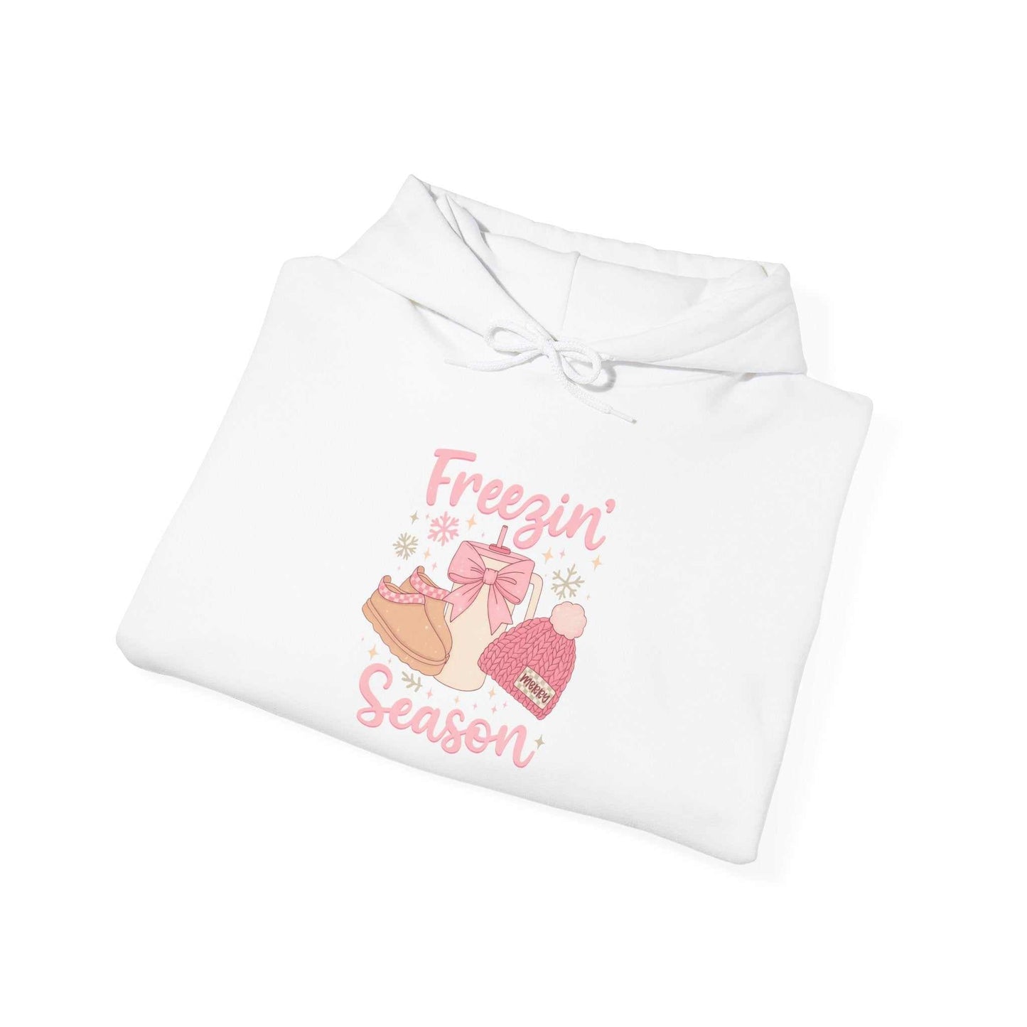 Cozy white winter hoodie with pink "Freezin' Season" graphic featuring boots, hat, and mittens illustration
